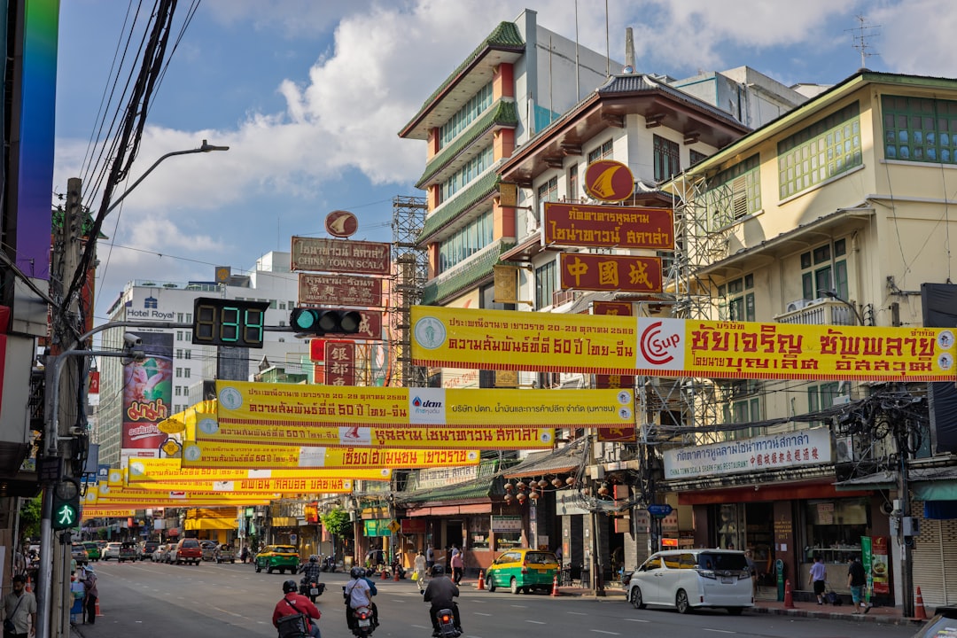 Bangkok's Chinatown street with colorful storefronts, Thai and Chinese signage, and traditional architecture